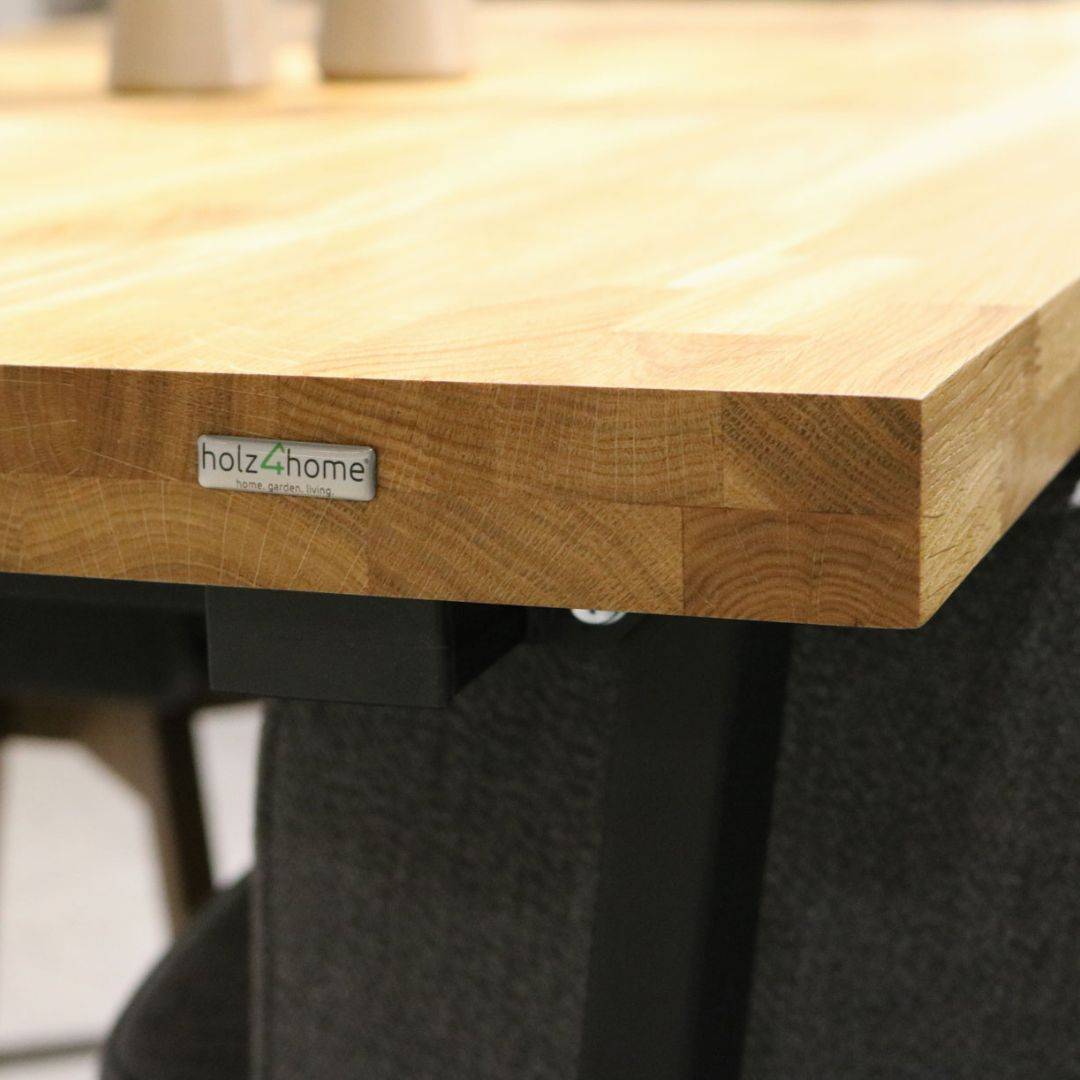 Close-up van de rechte rand van een massief eikenhouten tafelblad zonder boomstamrand met zichtbare opdikking en holz4home-logo