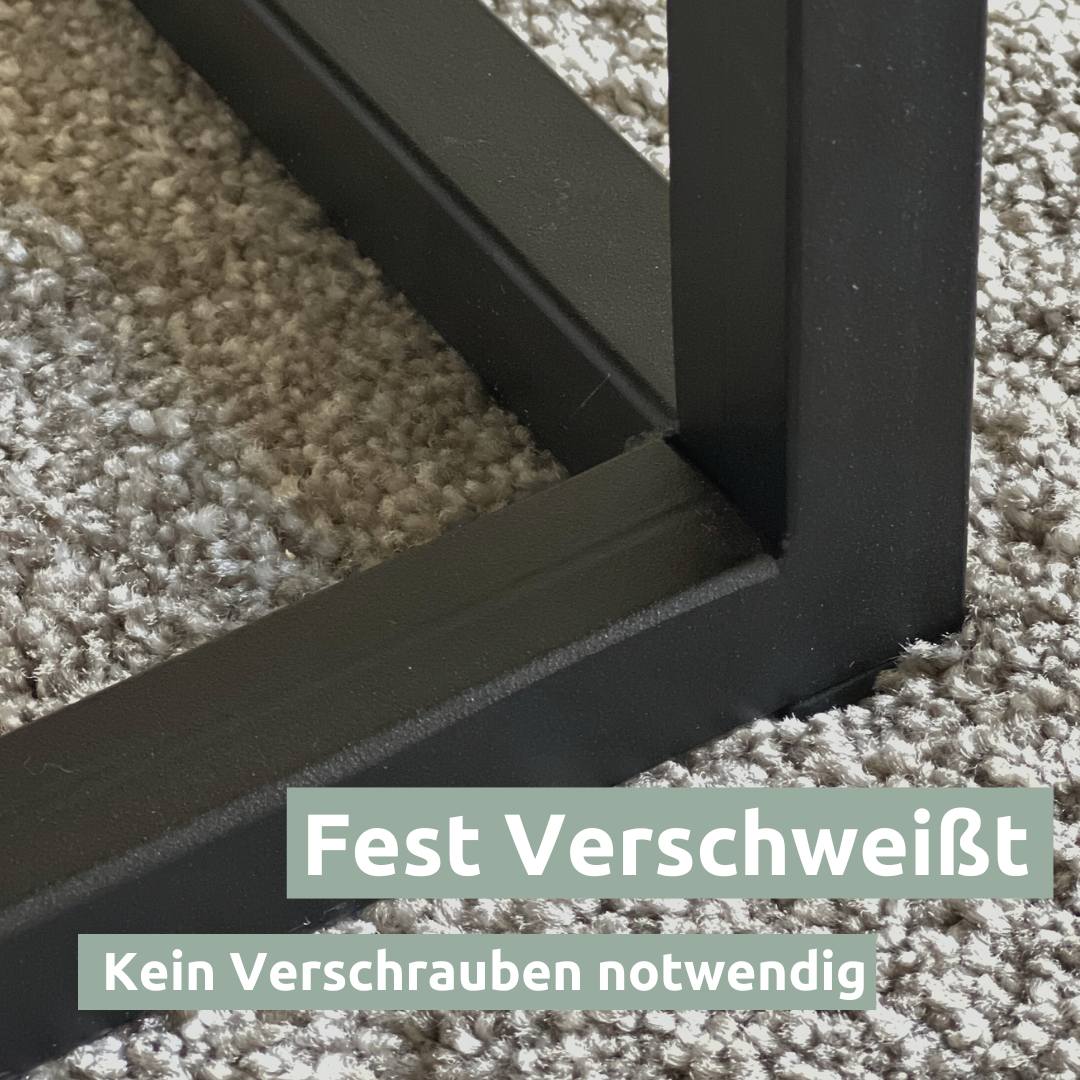Detail van het stevig gelaste zwarte metalen onderstel van de eiken salontafel