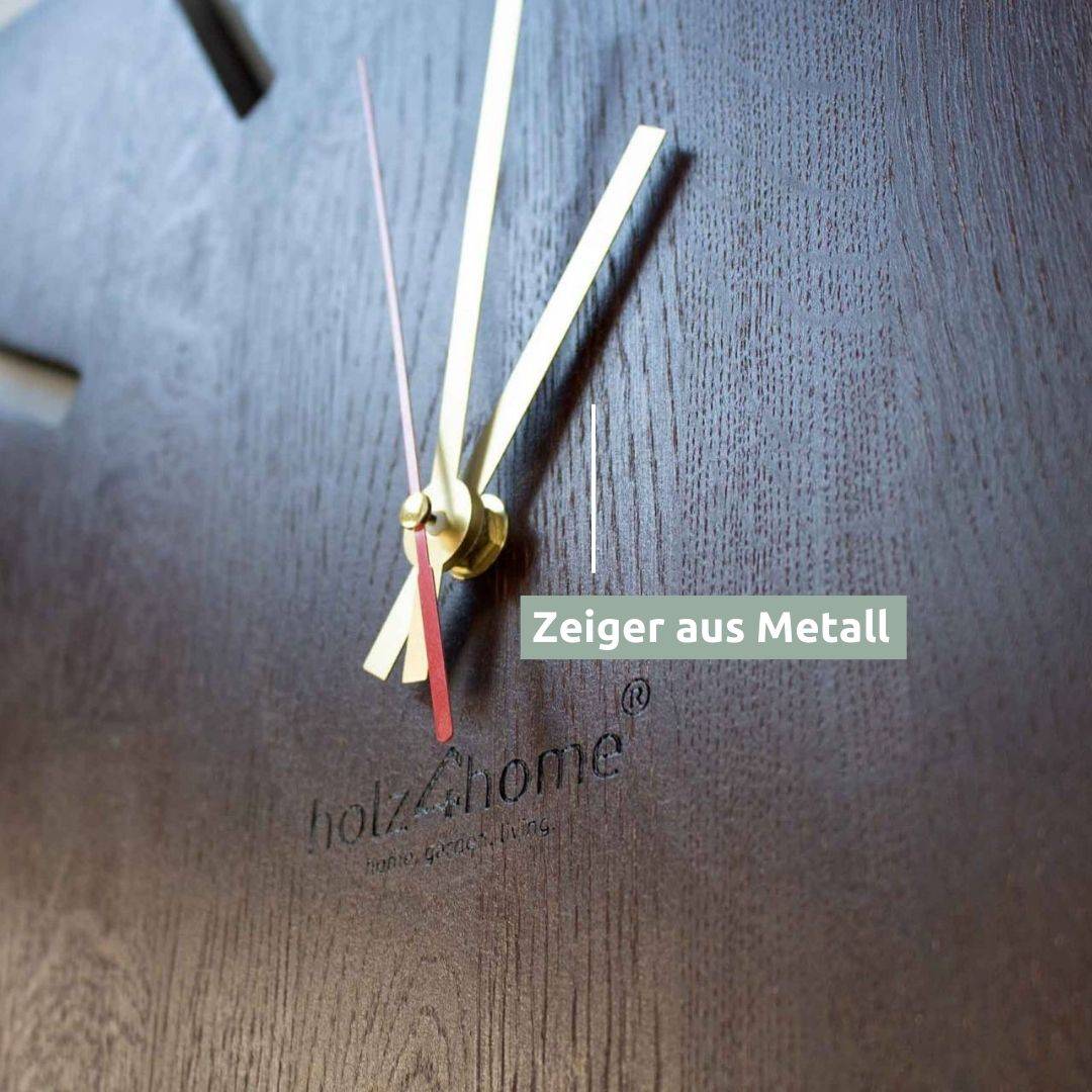 Close-up van de gouden metalen wijzers en de rode secondewijzer op de wandklok Sunshine XL