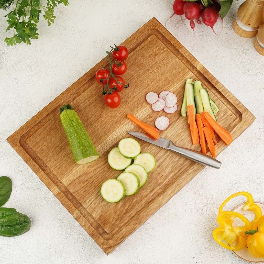 Snijplank Alina van eikenhout met gesneden courgette, tomaten en wortels, van bovenaf