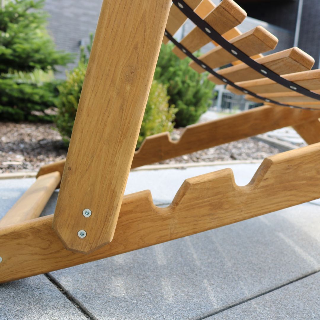 Detail van het verstelmechanisme met gekartelde klikrail aan de eikenhouten ligstoel