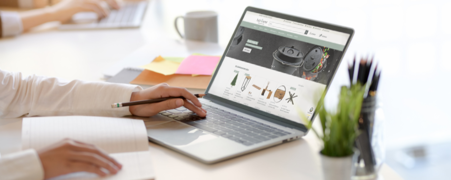 Persoon bekijkt de holz4home-productpagina van een Dutch Oven op een laptop op de werkplek