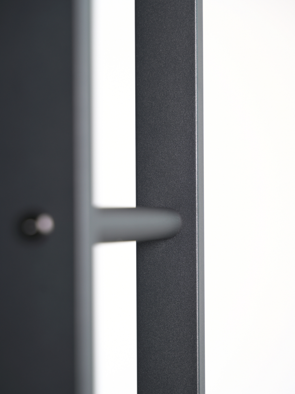 Close-up van het antracietkleurige haardhoutrek van metaal met mat frame en afgerond greepdetail