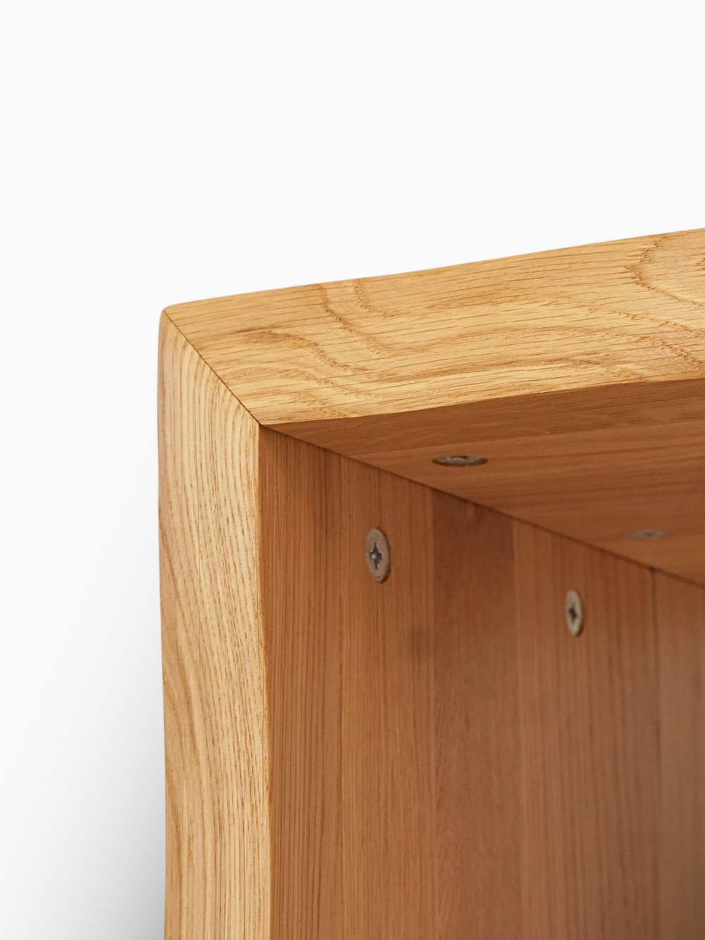 Detailopname van de verschroefde hoekverbinding en de boomstamrand aan de massief houten kruk van eiken