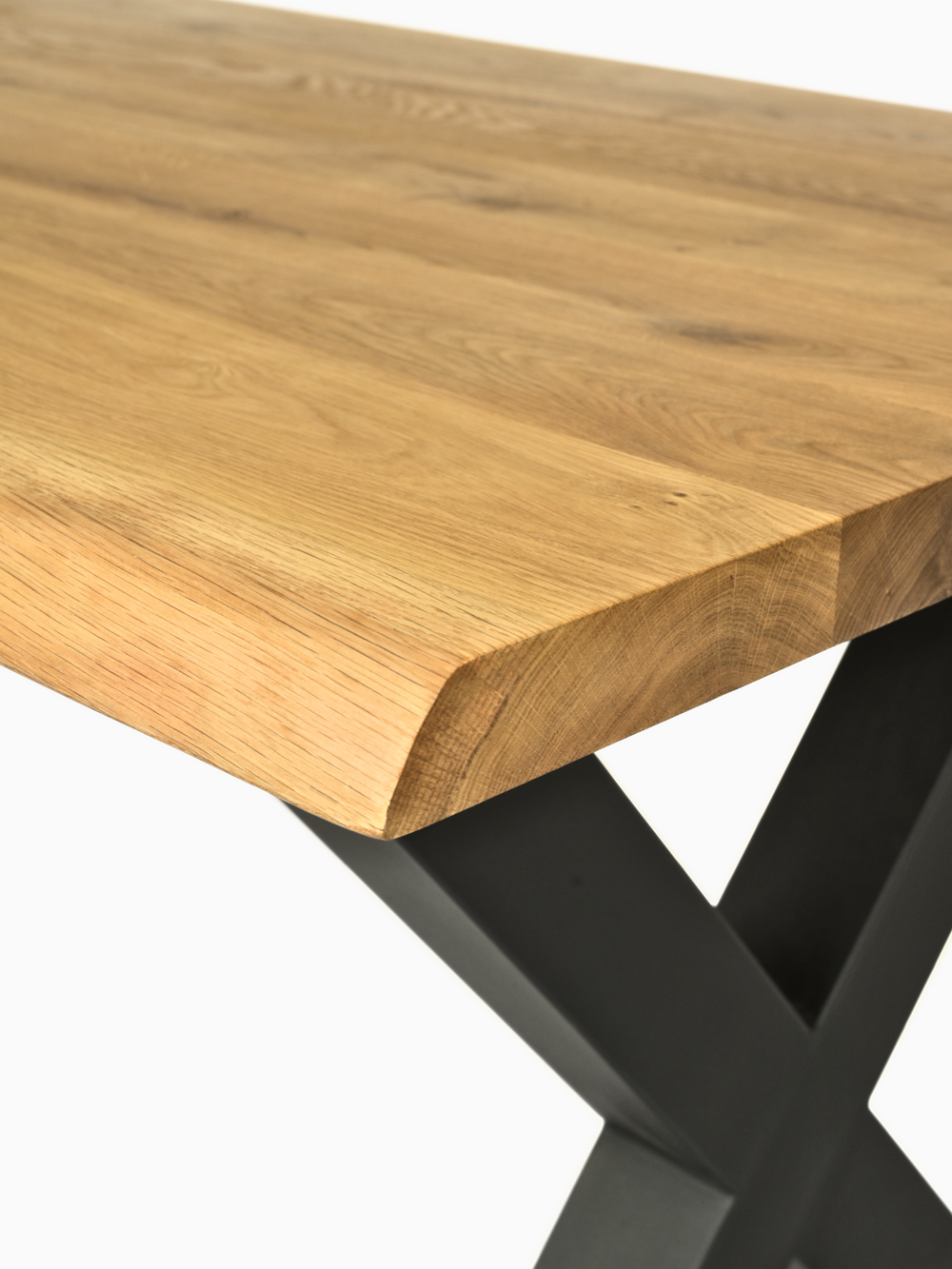 Detailopname van de boomstamrand van een massief houten tafel van eiken met natuurlijke nerf en zwart X-onderstel