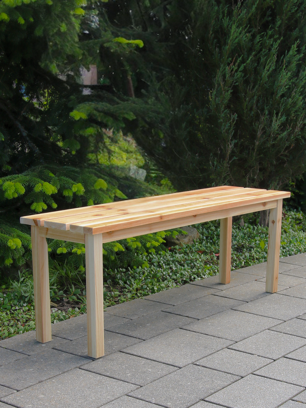Tuinbank van vurenhout op het terras voor naaldbomen in de tuin