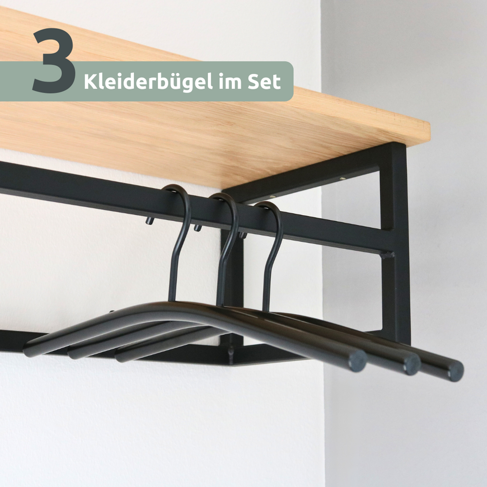 Drie zwarte kledinghangers in de set opgehangen aan een wandkapstok van eiken en metaal