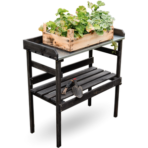 Houten plantentafel in zwart met zinken plaat, vooraanzicht met beplante houten kist en tuingereedschap