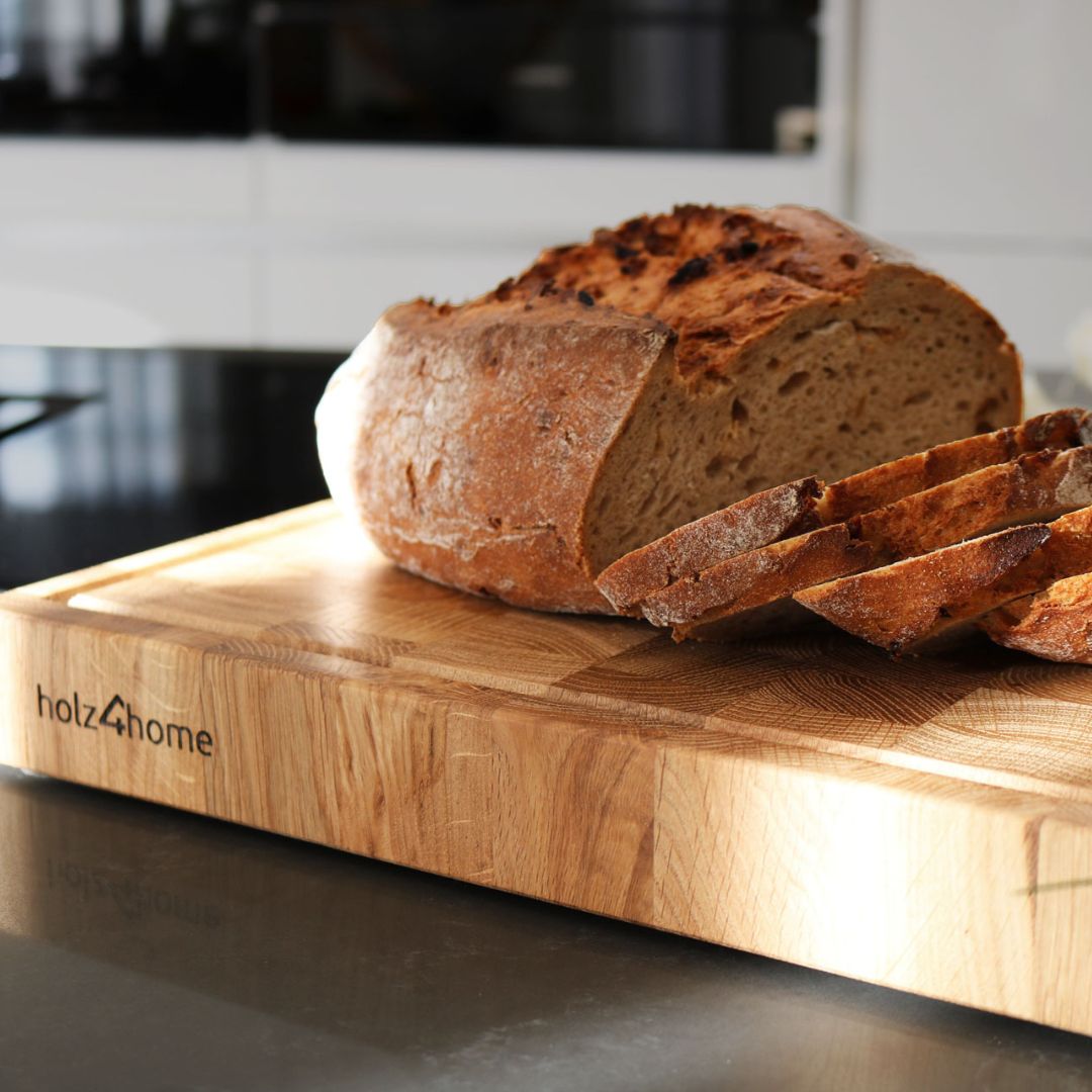 Snijplank van eikenhout met aangesneden brood op het keukenblad