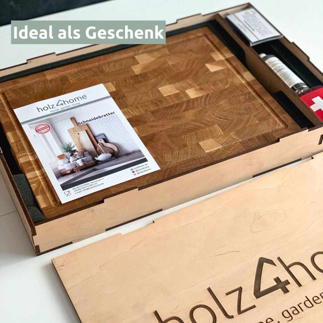 Geopende houten geschenkdoos met eikenhouten snijplank, catalogus en mes