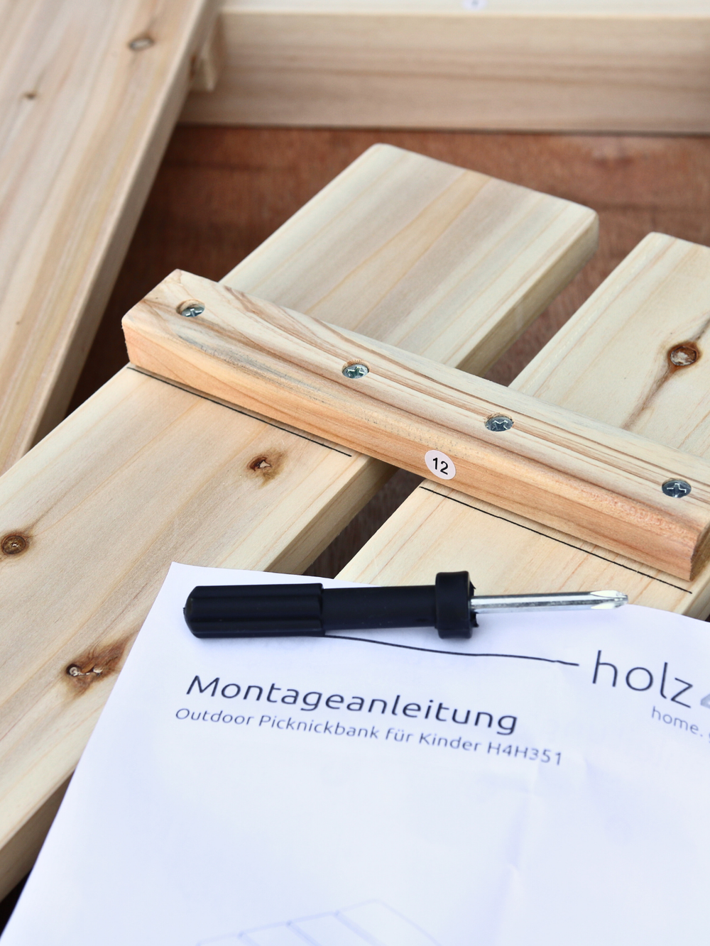 Montagehandleiding en gereedschap van de outdoor kinderpicknicktafel tijdens de opbouw