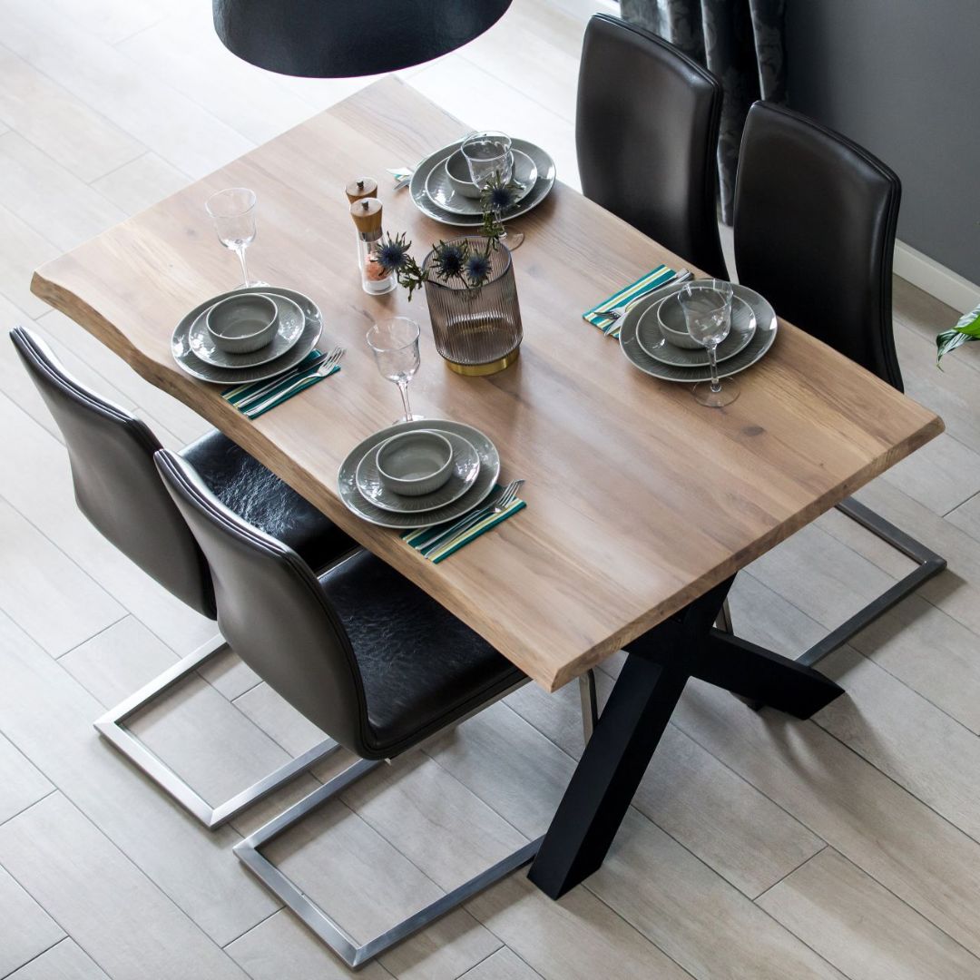 Eikenhouten tafelblad met boomstamrand als gedekte eettafel met donkere leren stoelen
