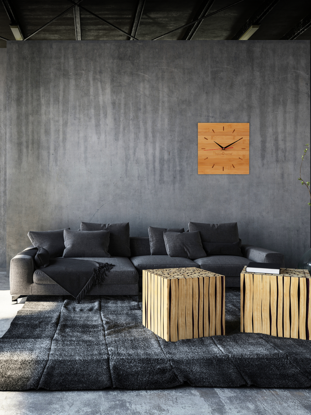 Bamboe wandklok aan een grijze betonnen muur in de woonkamer boven een antracietkleurige bank