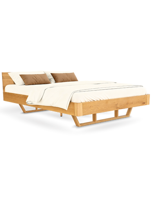 Massief houten bed van eiken met hoofdbord en sledepoten als tweepersoonsbed, opgemaakt met licht beddengoed
