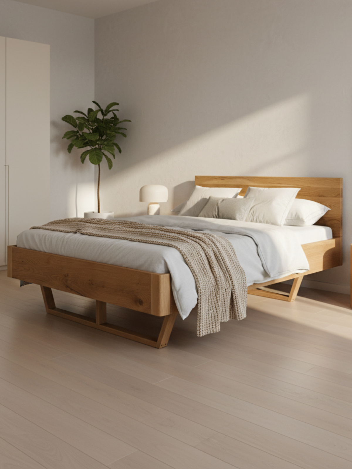 Massief houten bed van eiken in een lichte, minimalistische slaapkamer met kamerplant en lamp