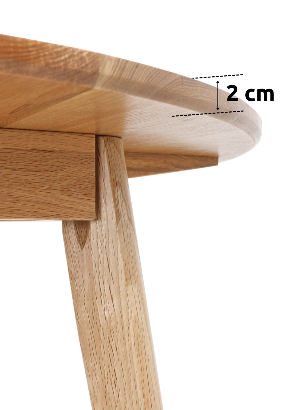 Detailopname van het 2 cm dikke tafelblad en de conische houten poot bij de ronde eettafel van eiken