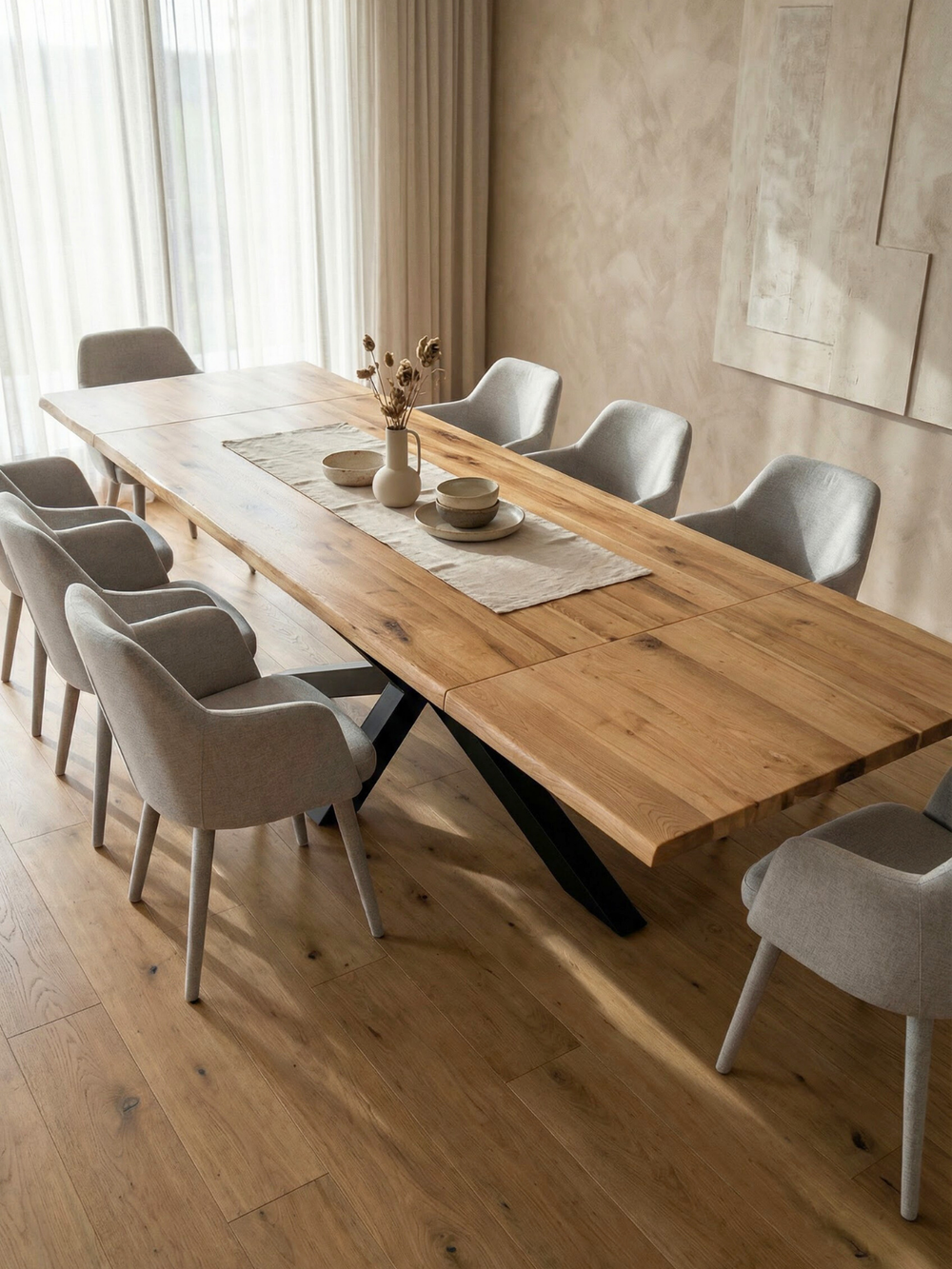 Uitgetrokken eikenhouten tafel met boomstamrand en zwart Spider-onderstel in de eetkamer met lichte gestoffeerde stoelen