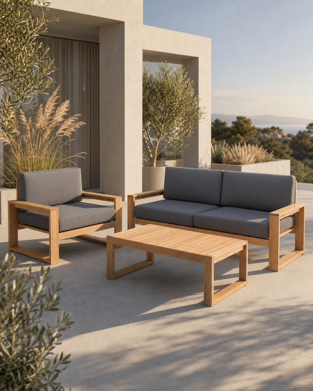 Tuinlounge van eiken met tweezitsbank, fauteuil en tafel met antraciet kussens op een terras met zeezicht