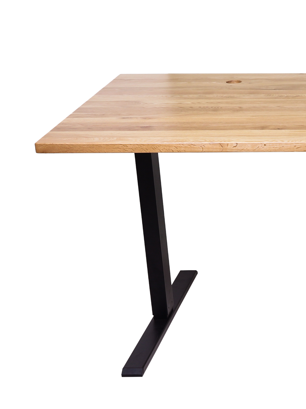 In hoogte verstelbaar bureau van eiken met zwart onderstel in een gezellig thuiskantoor met fauteuil