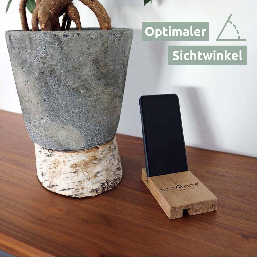 Telefoonhouder van eikenhout met smartphone in de optimale kijkhoek naast een plant op de tafel