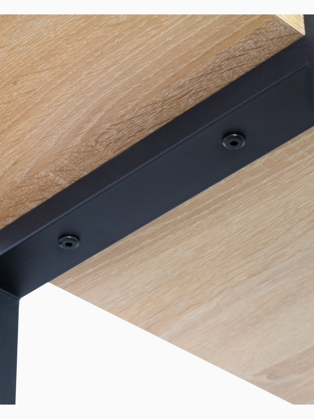 Detailopname van de verschroeving tussen de Sonoma eiken bodemplaat en het zwarte metalen frame van het wandrek