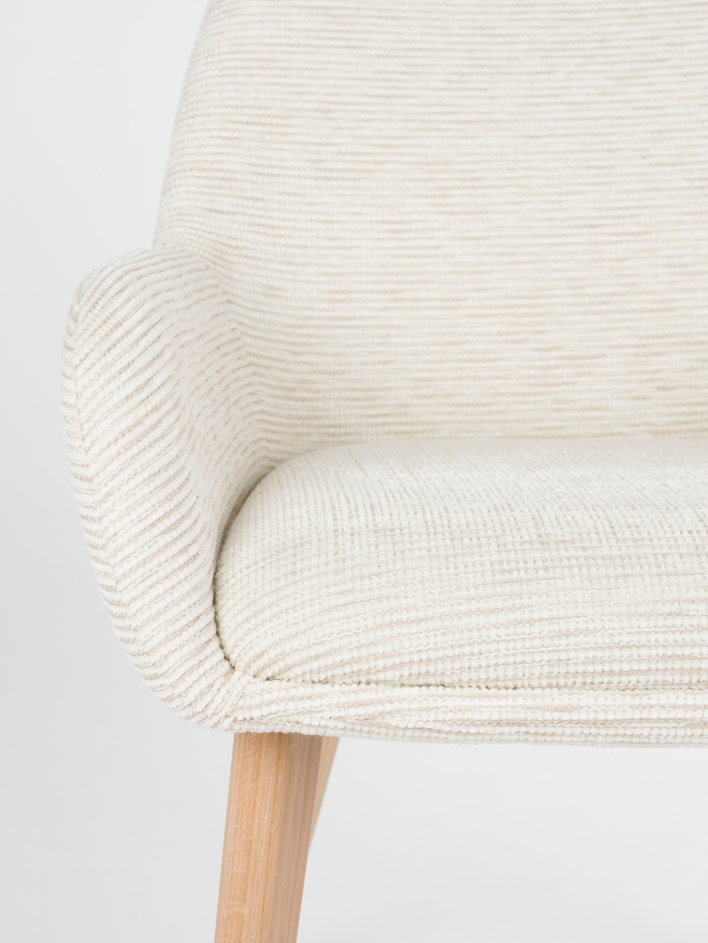 Close-up van zitvlak en armleuning met geribbelde off-white bekleding bij de armleuningstoel Loua