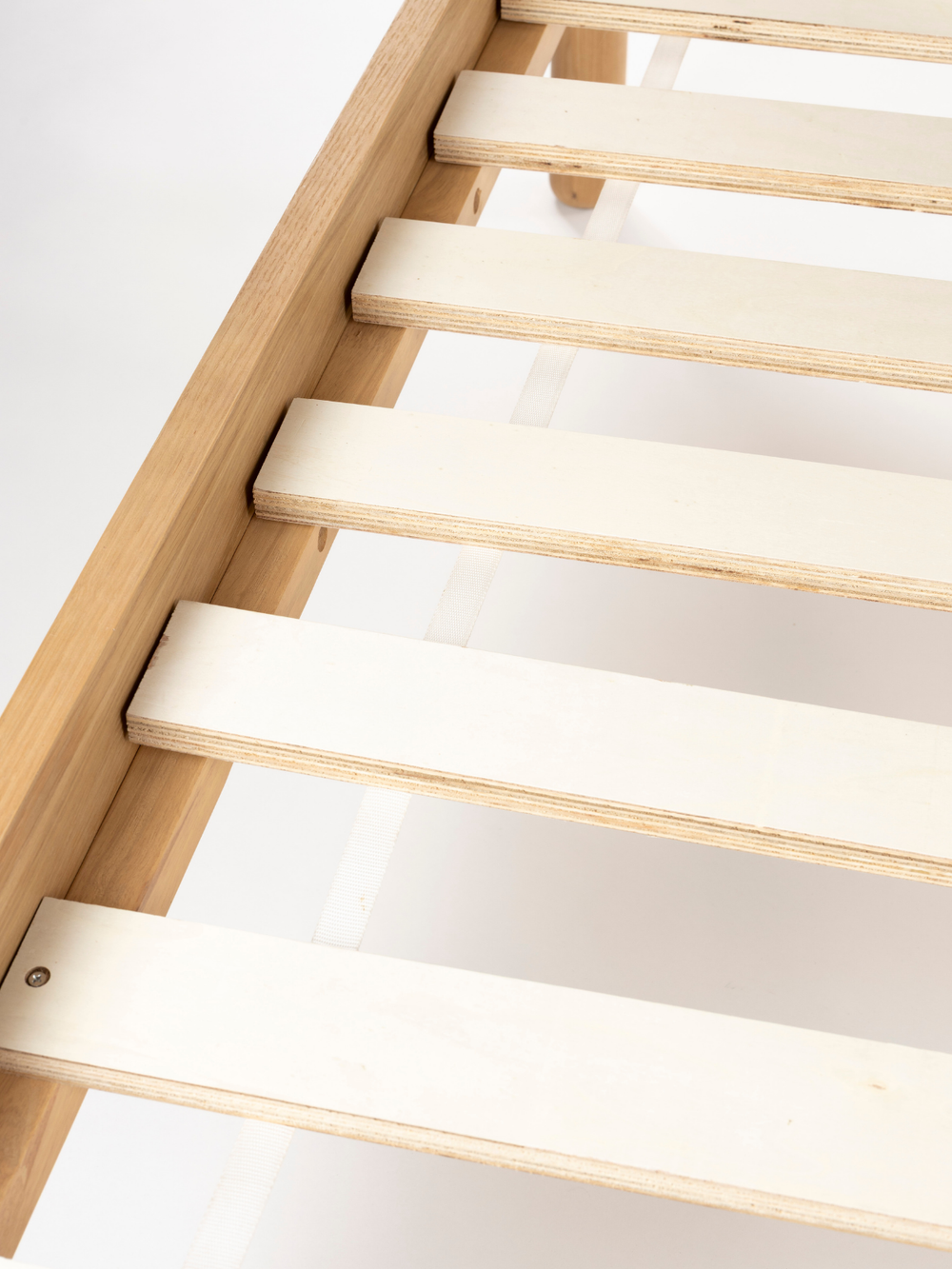 Opbouw van het bed met lichte verende latten op het frame van essenhout naturel, van bovenaf gezien