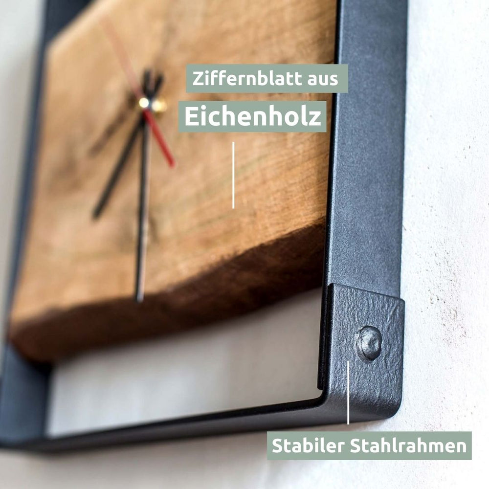 Detailopname van de wijzerplaat van eikenhout en het stevige zwarte stalen frame van de wandklok
