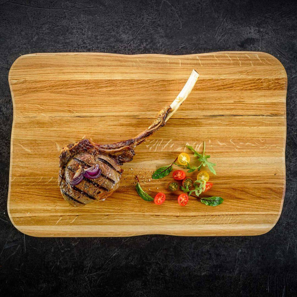 Tomahawksteak met tomaten en kruiden op de steakplank Master van licht eikenhout