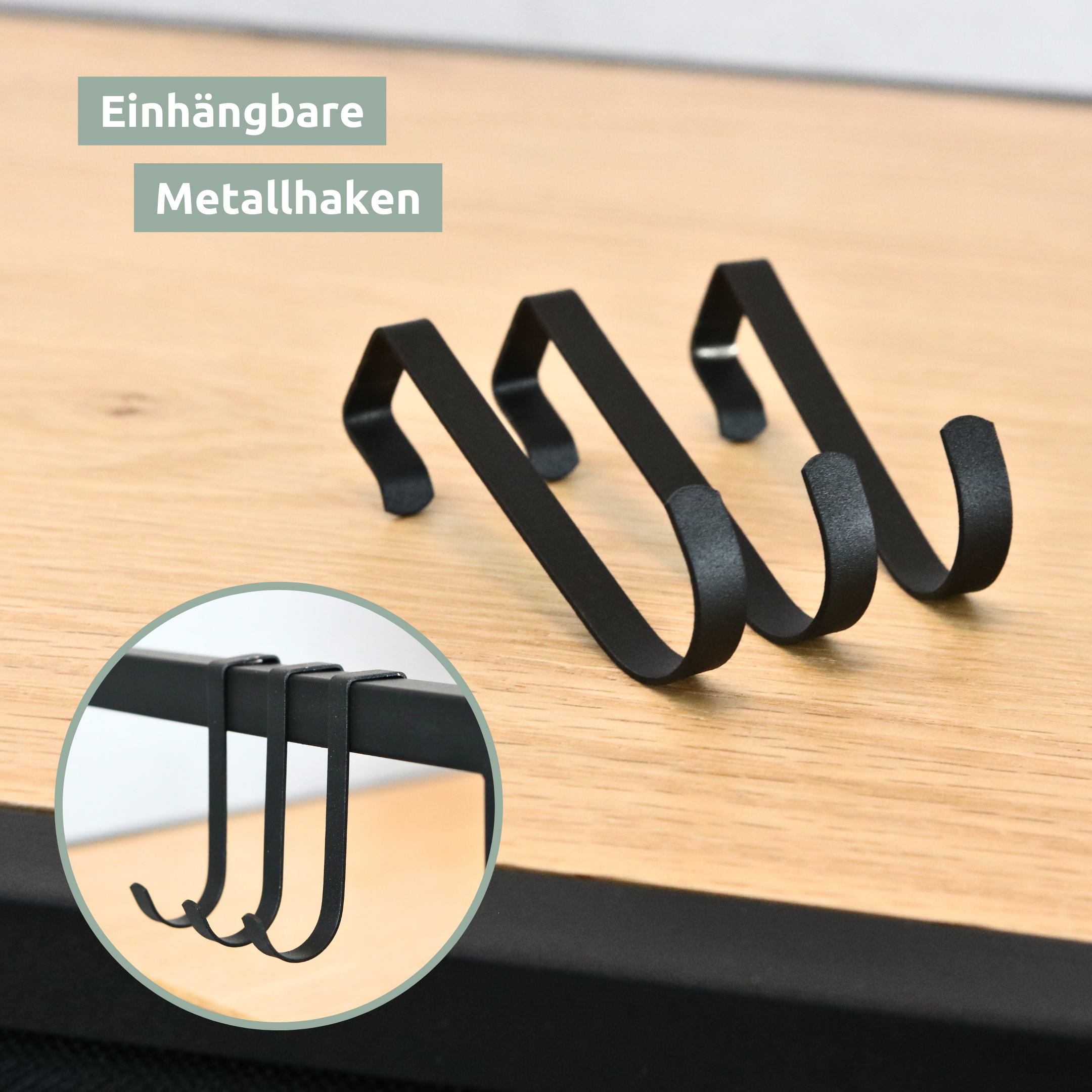 Drie inhangbare zwarte metalen haken van de wasmand op de houten plank, detailweergave