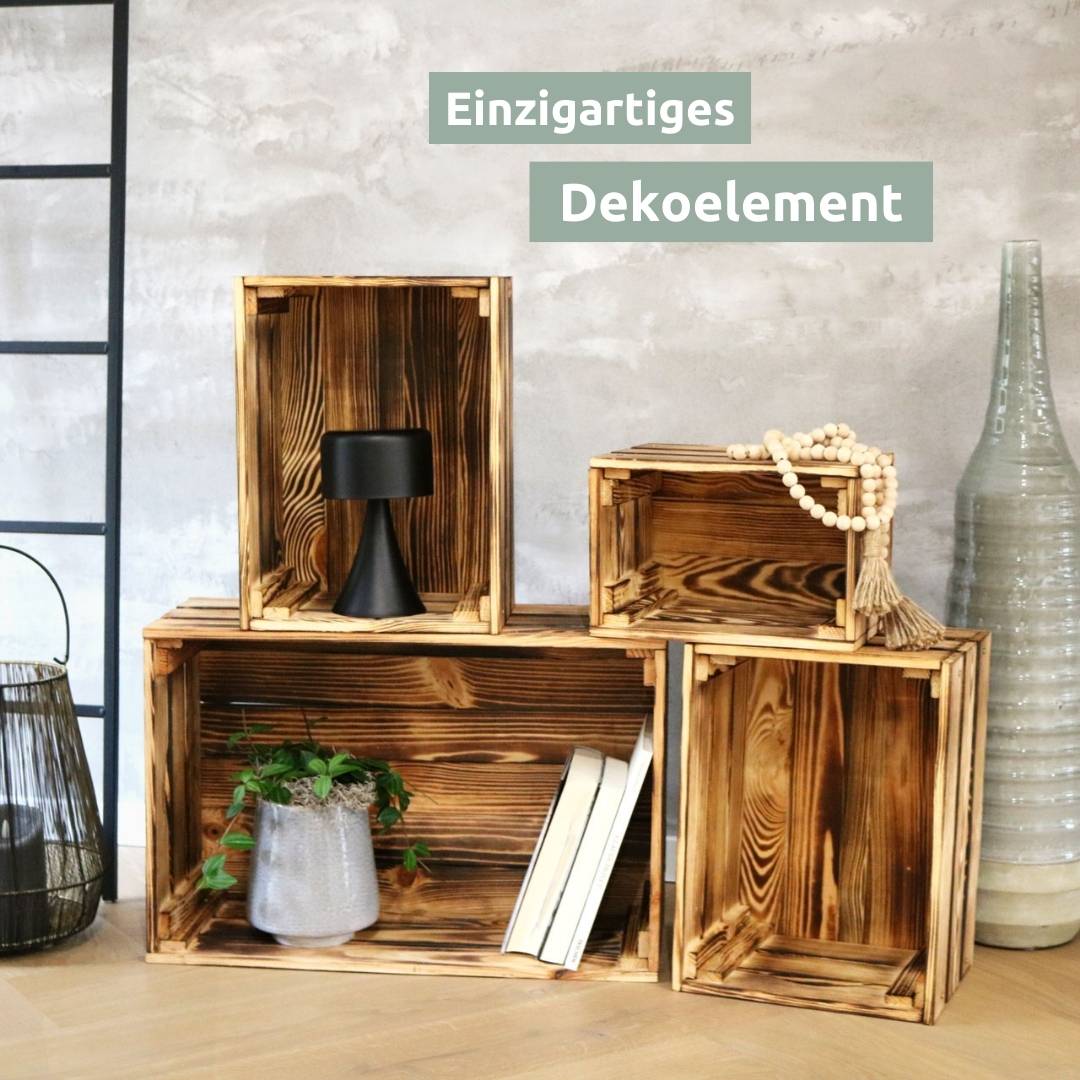 Gestapelde geflambeerde wijnkisten als woondecoratie met zwarte lamp, houten kralenketting en boeken