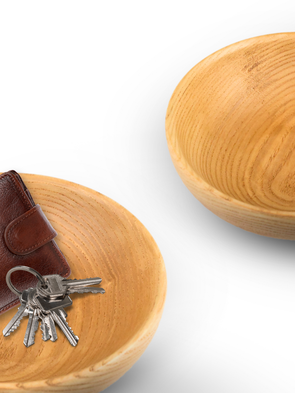 Twee houten schalen van essenhout als sleutelbakje getoond met portemonnee en sleutelbos